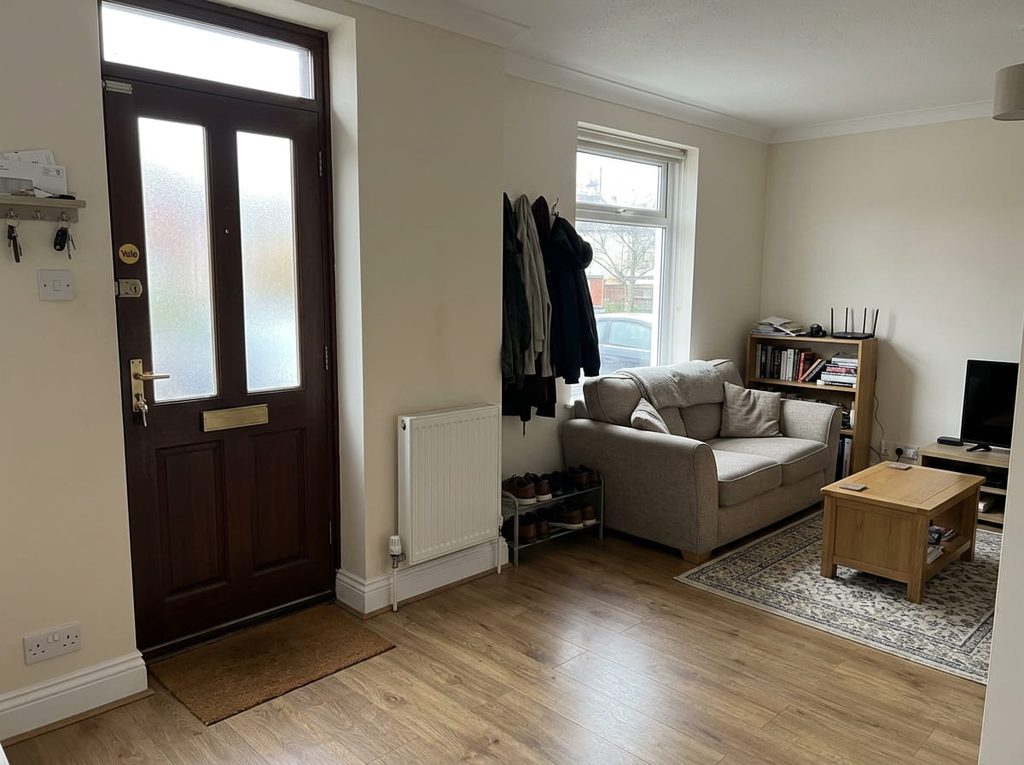 Compact UK room with radiator, shallow storage and small sofa